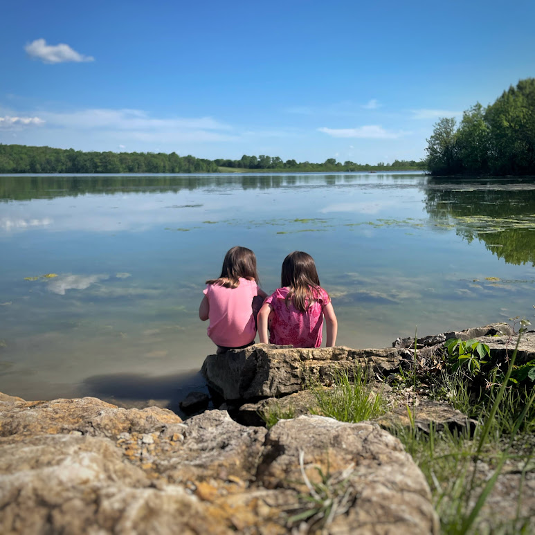 two girls looking into the water at Watkins Mill State Park while camping near Kansas City