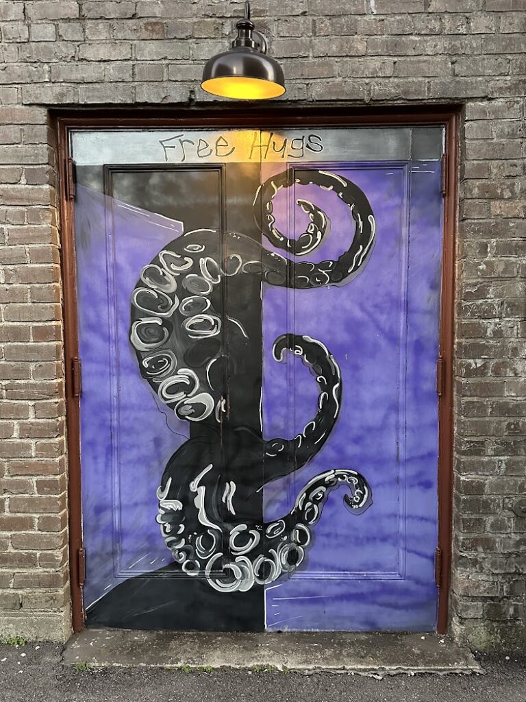 A painting of octopus tentacles coming out of a door at Art in the Alley in Hattiesburg, Mississippi. 