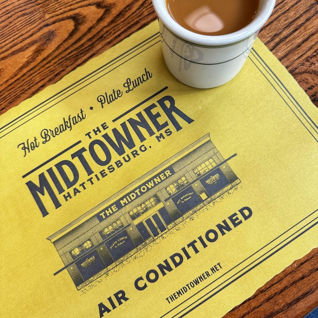 The Midtowner placemat in Hattiesburg, Mississippi with a cup of coffee. 