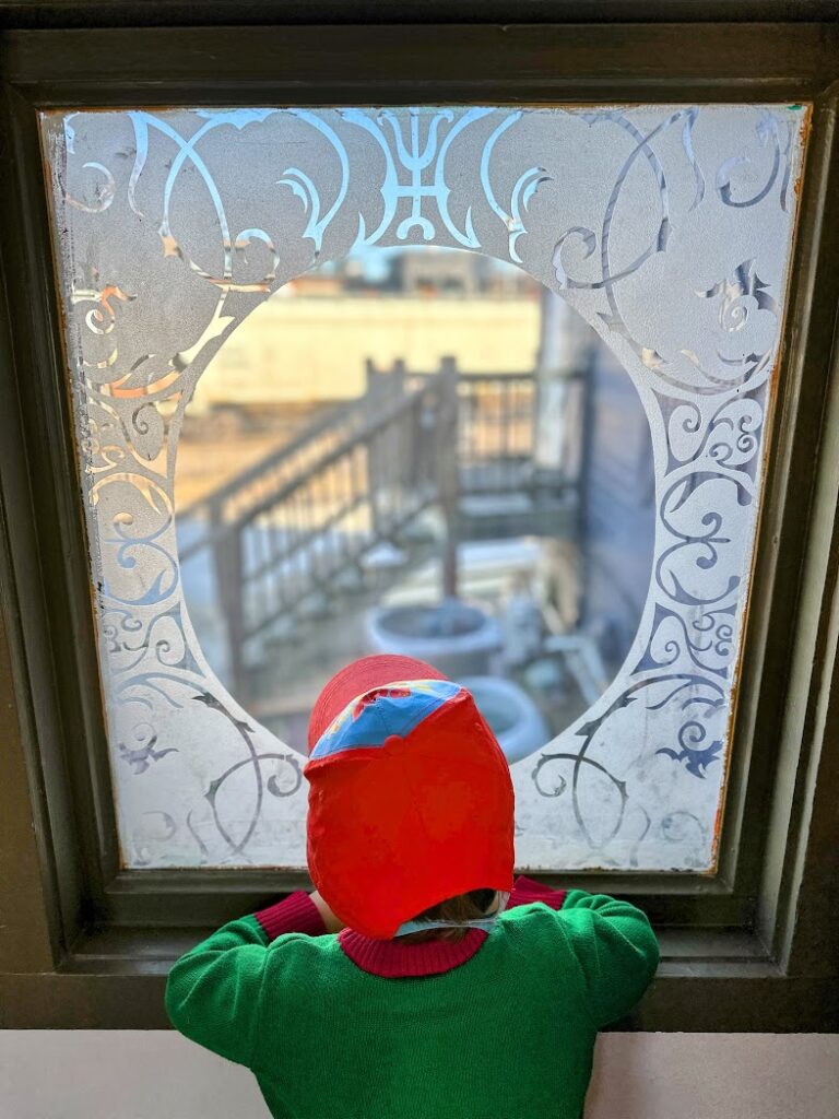 A boy looking out a window at a train at Rochester Brewing Co 