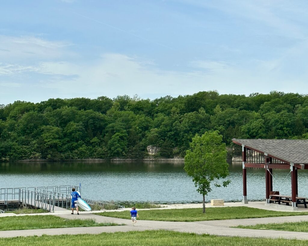 A fishing dock and park of a shaded pavilion at Lake Olathe 