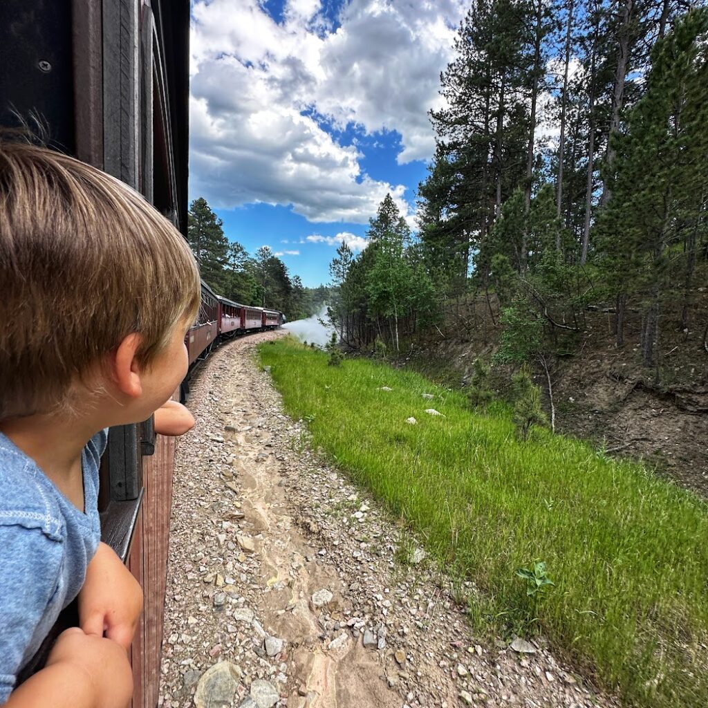 a little boy looking out of the window on the 1880's train in South Dakota 