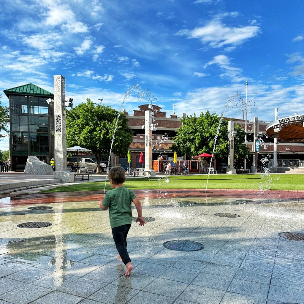 a boy running at the splash pad in downtown rapid city