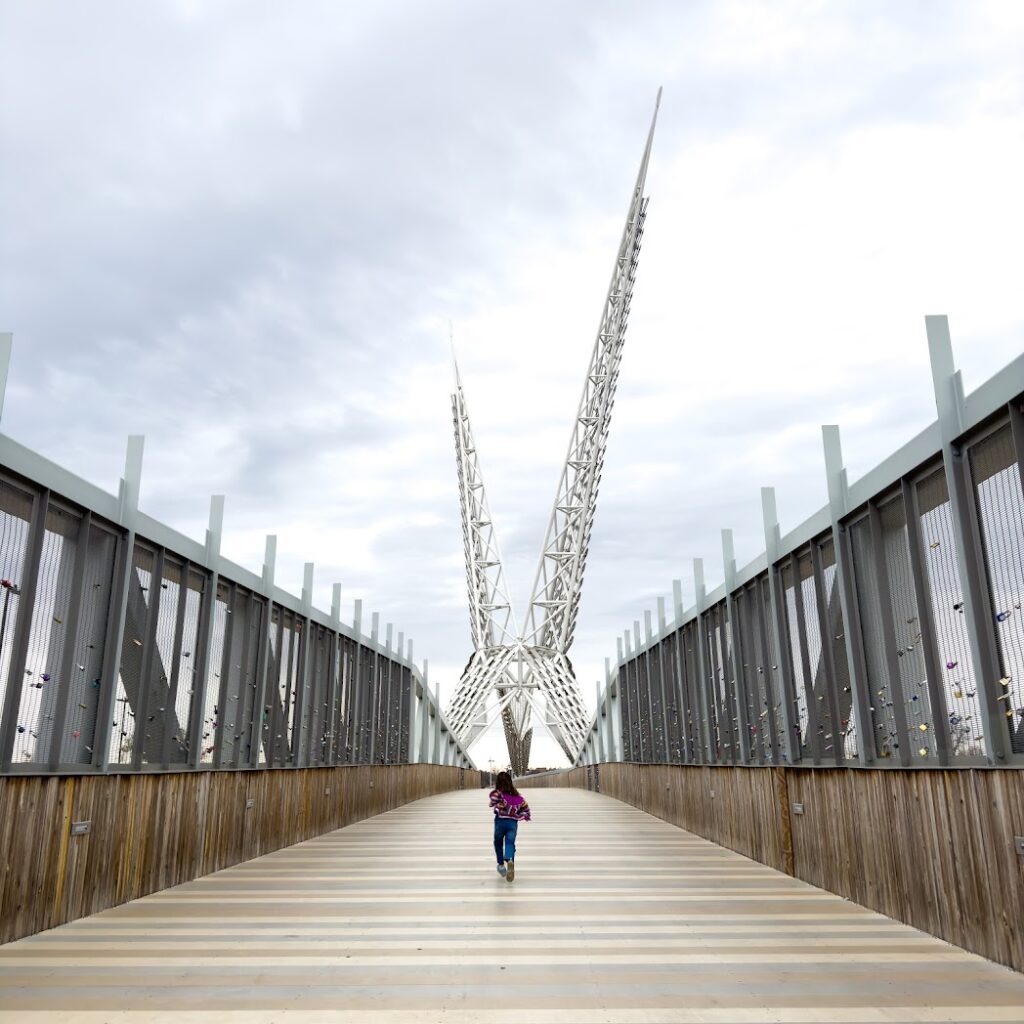 A girl running down a bridge at Scissortail Park in Oklahoma City, a great weekend trip from Kansas City