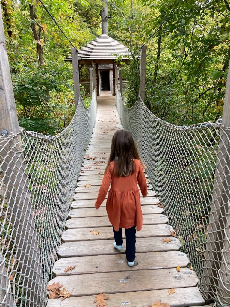 A girl walking in the treetop village at Arbor Day Farm 