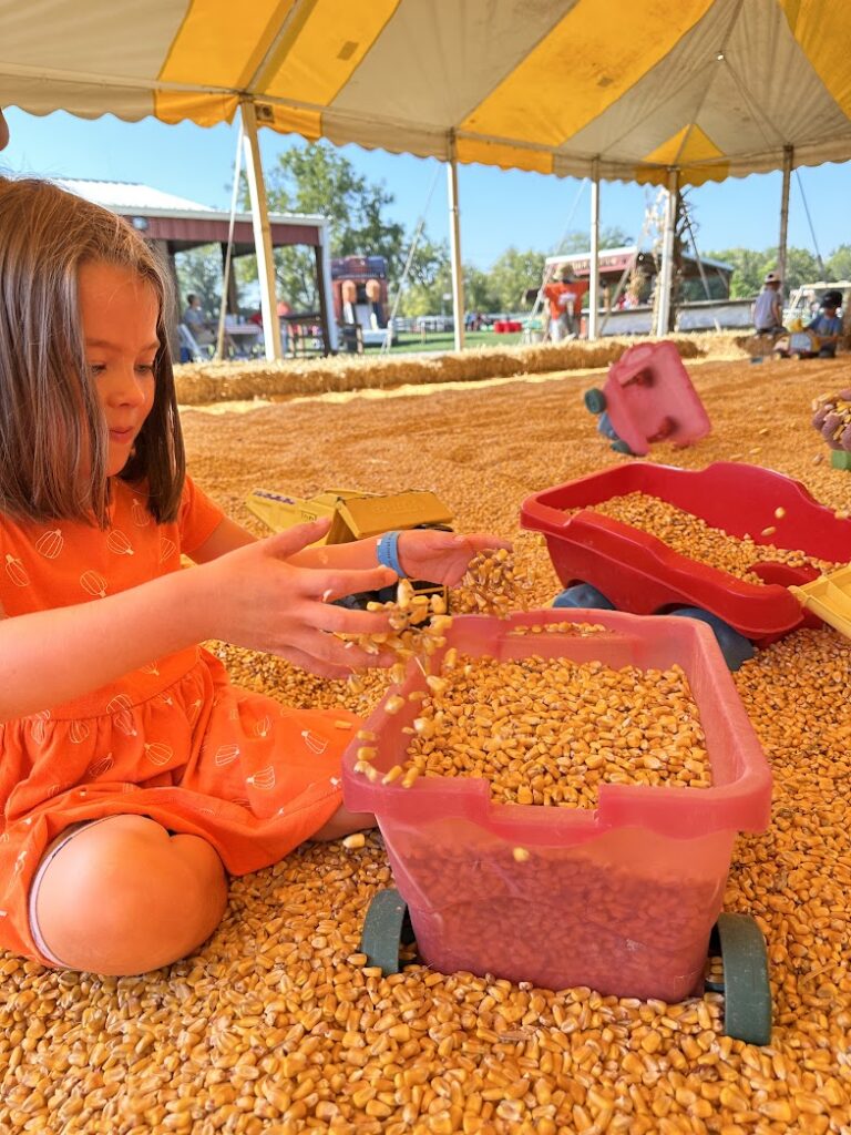 a girl playing in a corn crib 