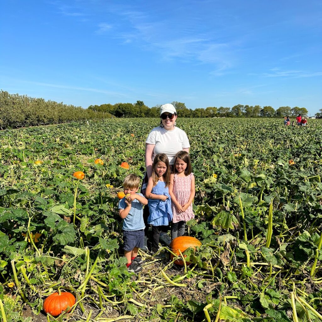 A family standing in the middle of a pumpkin patch in Kansas City