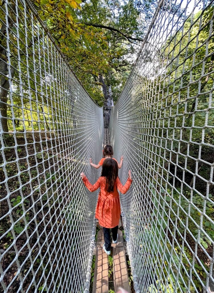 a picture of girls running along a rope bridge at Arbor Day Farm Treetop Adventure, Nebraska City, Nebraska