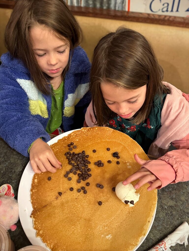 Two girls looking at a giant pancake at Billy Gails in Christmas in Branson