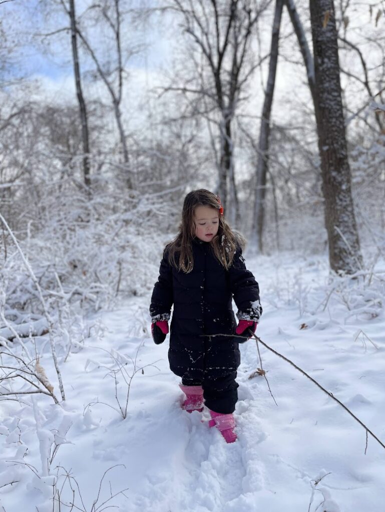 A girl walking in the woods in the snow